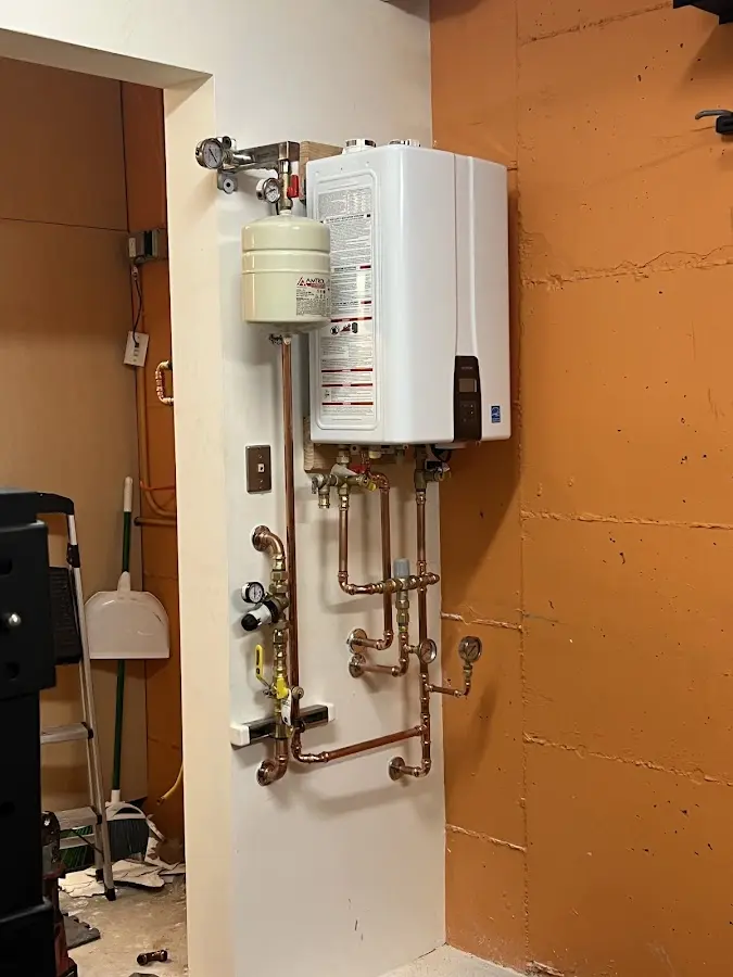 Plumbing technician inspecting water heater connections in Harwich